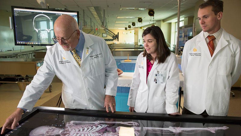 첥 professor and students using a simulator in the 첥 College of Medicineâs Anatomy Laboratory