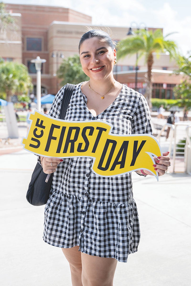 Photo of a student holding a sign with the words 첥 First Day printed on it